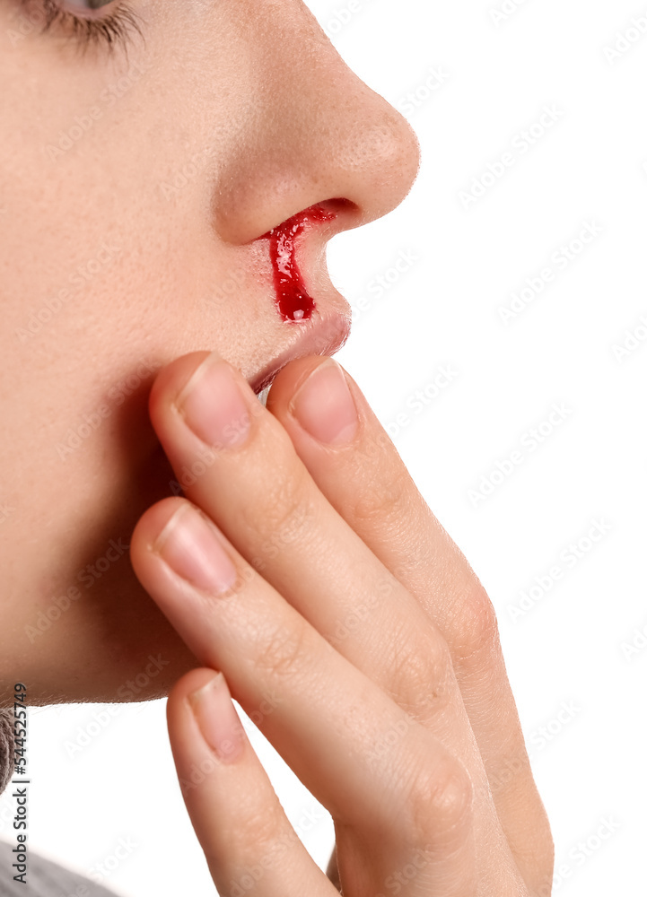 Young woman with nosebleed on white background, closeup Young woman with nosebleed on white background, closeup