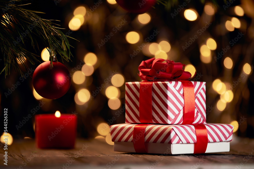 gift boxes and a red candle on a Christmas background .