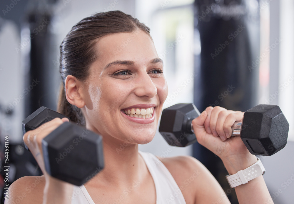 Fitness, exercise and woman with dumbbell in the gym doing workout, training and weight lifting. Health, wellness and happy female exercising with equipment in sports center with smile on face Fitness, exercise and woman with dumbbell in the gym doing workout, training and weight lifting. Health, wellness and happy female exercising with equipment in sports center with smile on face