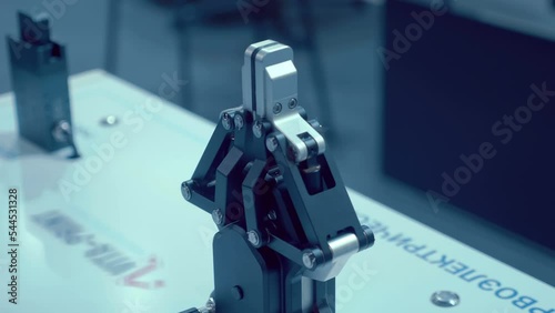 Mechanical metal powerful gripper for robotic arm (manipulator). Shot in motion. Closeup photo