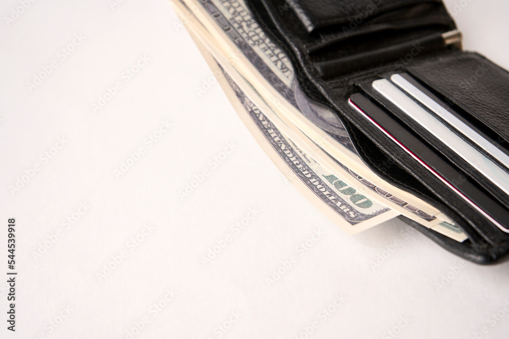 Black leather wallet with dollar money on a white background Black leather wallet with dollar money on a white background