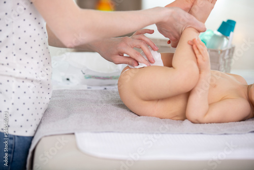 Tablou pe pânză a mother changing baby diaper