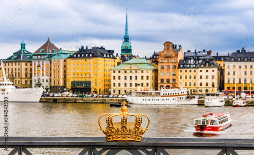 Foto A crown on the bridge in Stockholm with Gamla Stan embankment in the background