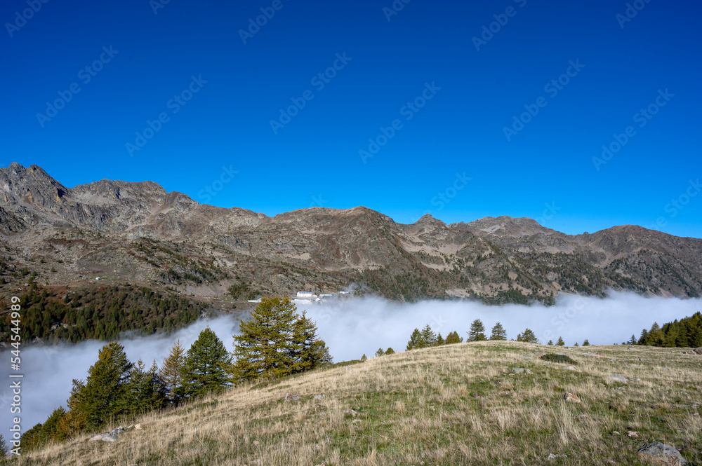 Paysage dans les Alpes autour du col frontière de La Lombarde en Italie à l'automne avec du brouillard dans la vallée