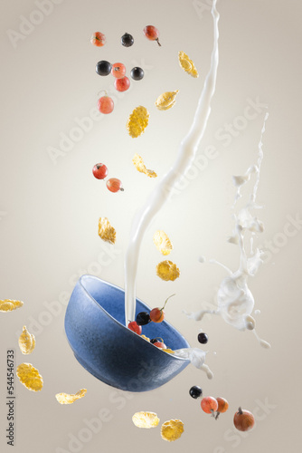 plate with corn flakes. flying food. corn flakes with milk and berries. milk splash with cereal and berries. breakfast with milk and cereal