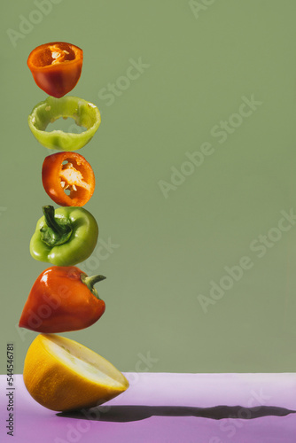 peppers and zucchini. pyramid of peppers and zucchini. flying food. save space with vegetables. sweet crispy pepper cut into rings on a green background