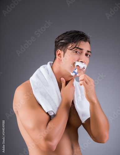 Man shaving on dark background