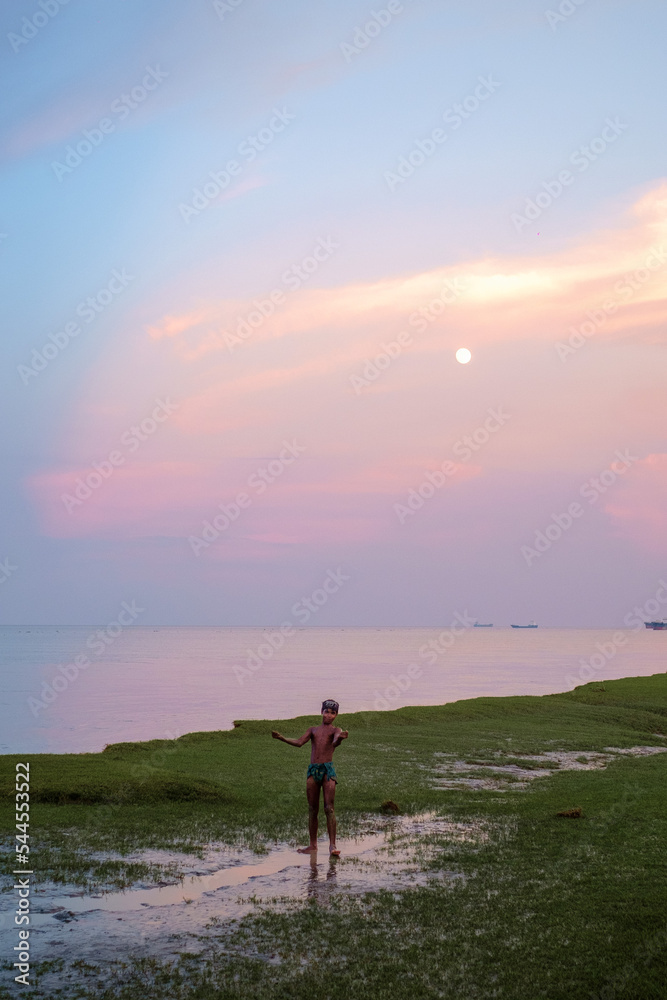 south asian village kid doing exercise in moonlit evening 