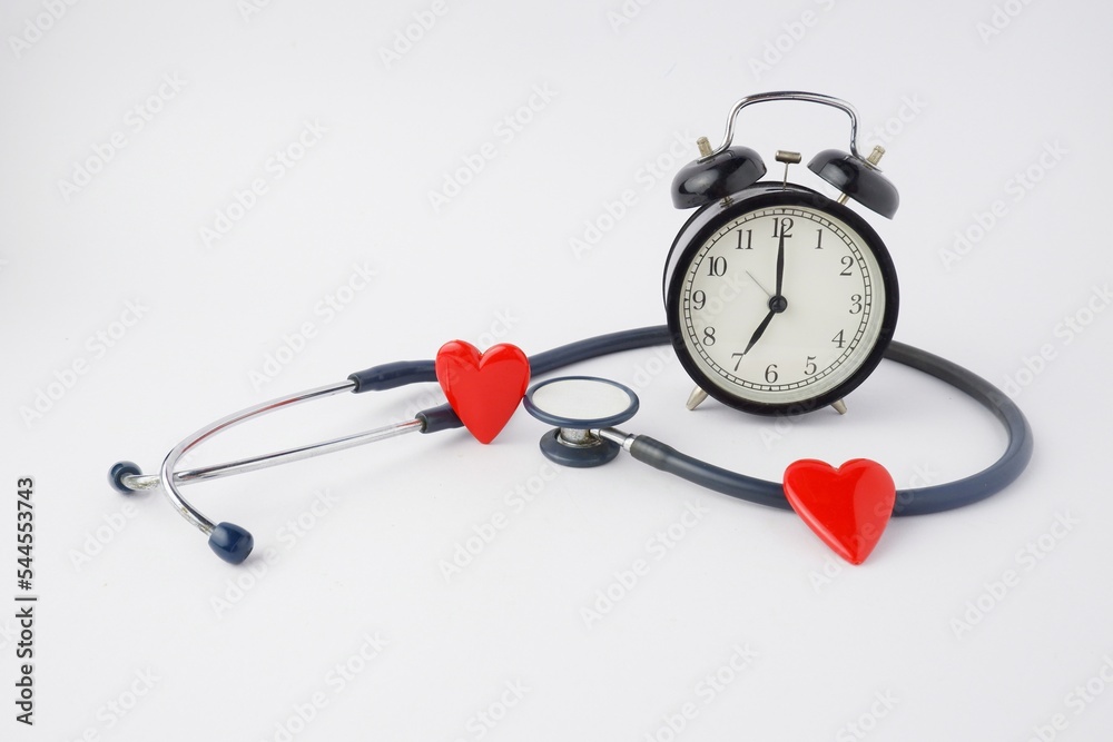 black alarm clock with medical stethoscope and red heart isolated on white background black alarm clock with medical stethoscope and red heart isolated on white background