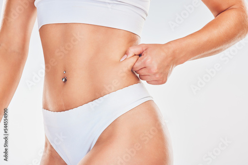 Health, body and wellness, skin and fat with diet and fitness, weightloss with exercise or liposuction against white studio background. Model in underwear, stomach and slim waist and losing weight. © Allistair F/peopleimages.com