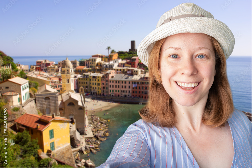 tourist taking a selfie with landmarks, italian travel, tourist international trip,tourism and travel, happy woman in a hat is photographed against the background of varnazza cinque terre