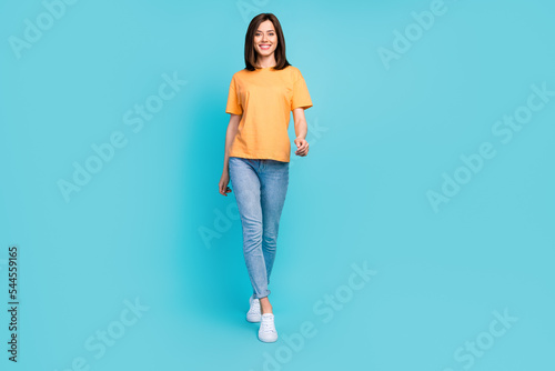 Fotografie, Obraz Full body photo of satisfied glad girl walking toothy smile isolated on blue col
