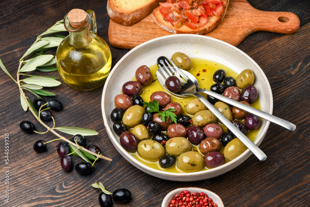 Different kinds of olives with olive oil and herbs Different kinds of olives with olive oil and herbs