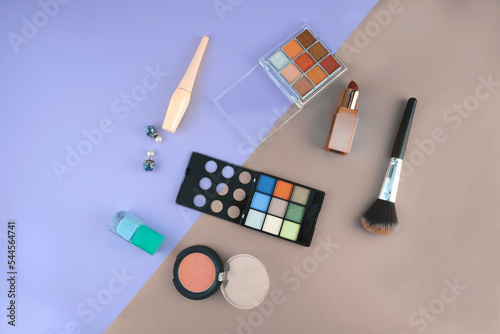 top view cosmetics lipstick makeup brush eyeshadow eyebrow pencil blush eyeliner on colorful background