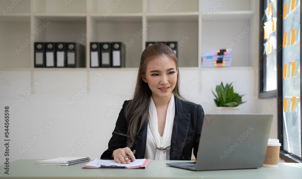 Young woman working on a laptop in the office. Asian businesswoman sitting at her workplace in the office. Beautiful Freelancer Woman working online at her home. Young woman working on a laptop in the office. Asian businesswoman sitting at her workplace in the office. Beautiful Freelancer Woman working online at her home.