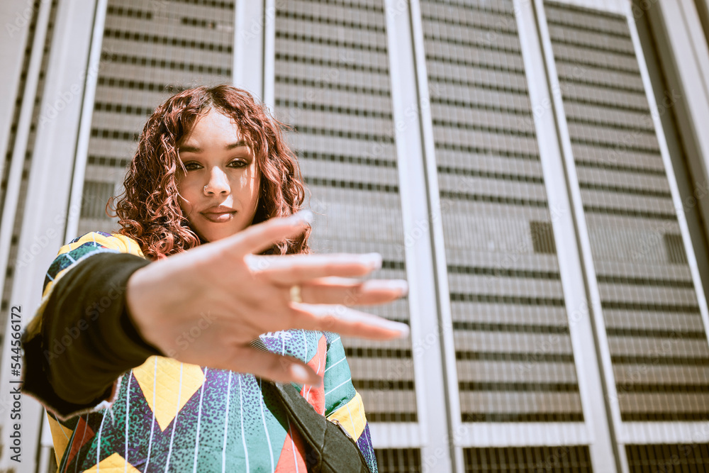 © C Daniels/peopleimages.com - Black woman, hand or fashion clothes in city center, town or urban location in New York city cool, trendy or style clothing. Portrait, model or student by buildings in funky, hipster or retro shirt