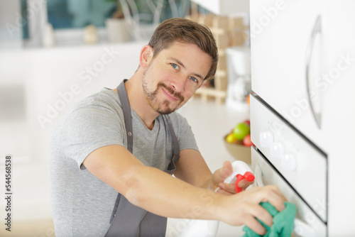 man cleaning oven in kitchen