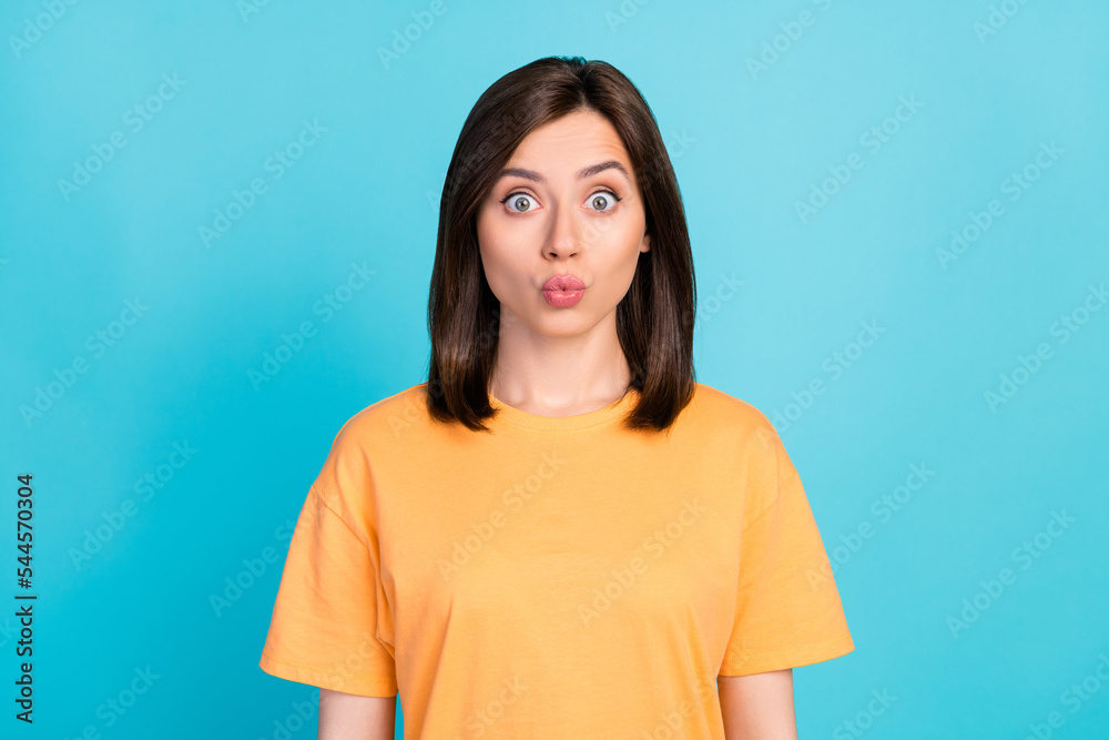 Fototapeta premium Photo of nice cute astonished girl with straight hairdo wear yellow t-shirt staring pouted lips kiss isolated on blue color background