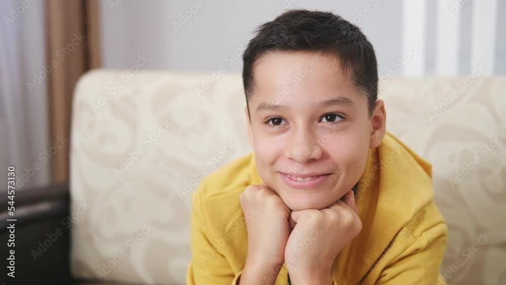 Close up portrait of happy positive teenage boy laughing at funny joke looking TV. Cheerful teen having fun, smiling face. Close up portrait of happy positive teenage boy laughing at funny joke looking TV. Cheerful teen having fun, smiling face.