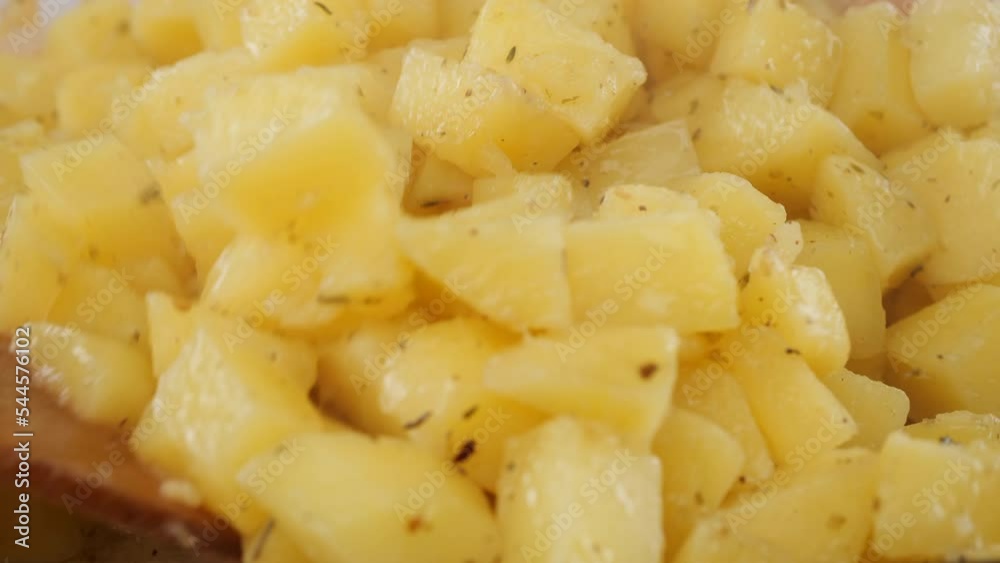 Chopped baked potatoes stir with wooden spoon, close up Chopped baked potatoes stir with wooden spoon, close up