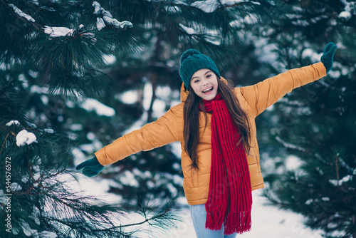 Portrait of attractive funky cheerful pre-teen girl wearing warm clothes spending free time having fun in forest outdoors #544576572