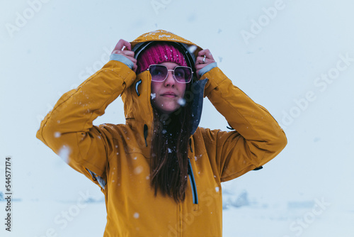 Obraz na płótnie woman in the snow with yellow coat, hat and sunglasses w salonie