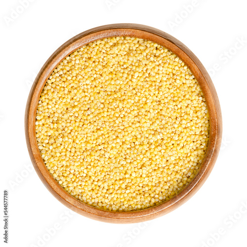 Hulled yellow millet, in a wooden bowl. Small-grained, annual cereals, belonging to the tribe Paniceae. Gluten-free grain, the most nutritious grain that is high in starch, also used as bird feed. photo