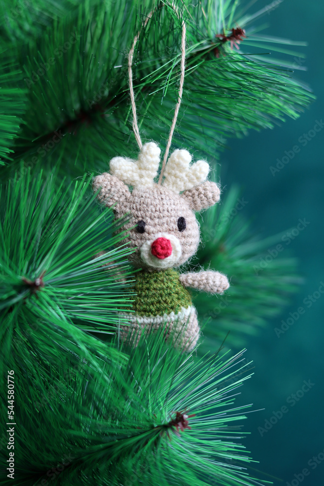 Obraz premium Cute Crochet Christmas tree ornament. Hand made Christmas decoration. Crochet toy close up photo. Environment friendly gift for Christmas. 
