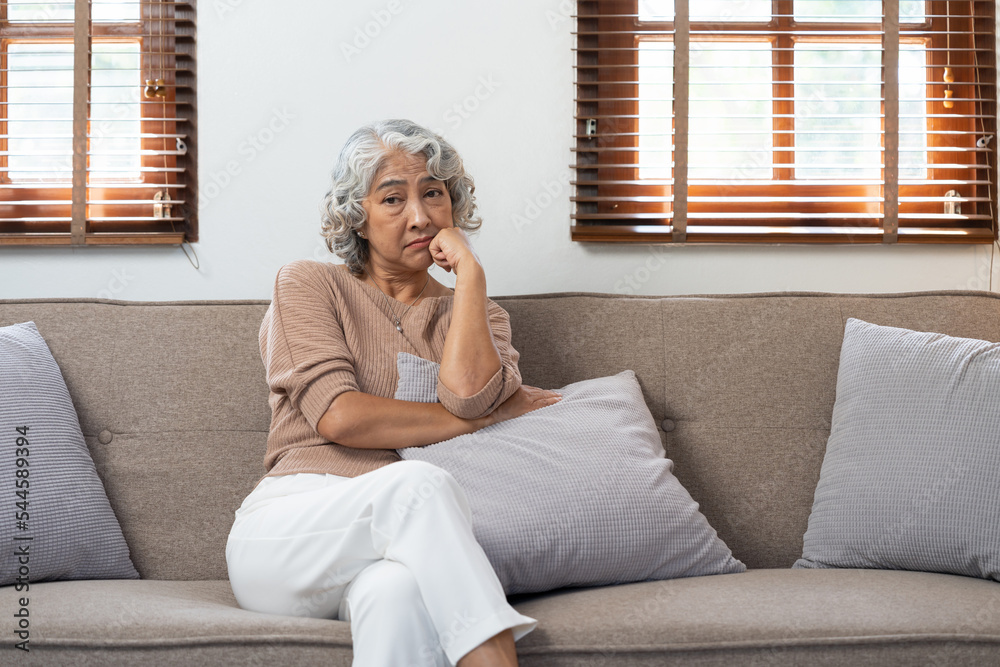 Asian elderly senior female at nursing home living room feeling sad missing unhappy thoughtful in mental health care in older people.
