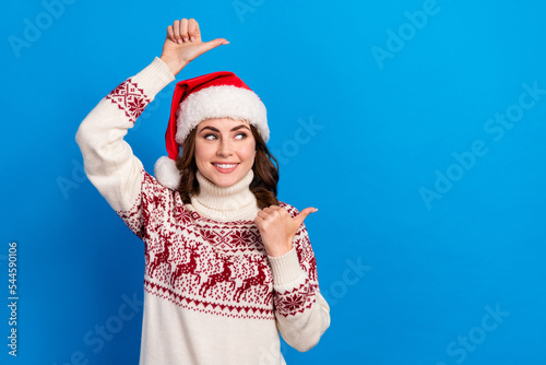Photo of pretty lady wear stylish print sweater two arm direct empty space look x-mas sale proposition isolated on blue color background