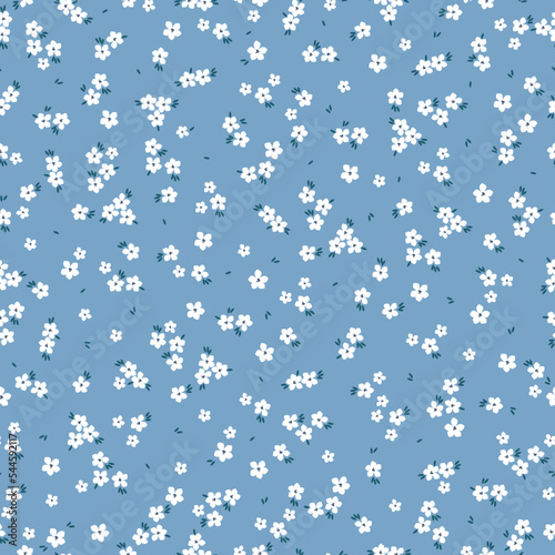 Cute floral pattern. Seamless vector texture. An elegant template for fashionable prints. Print with small white flowers, dark blue leaves. blue  background.
