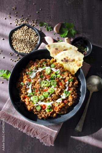 Lentil with vegetables served with sream and naan bread. Top view. Vegetarian and vegan food.