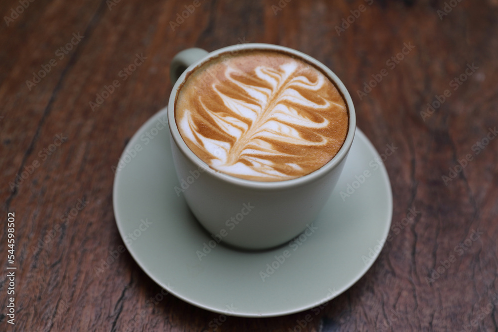 hot cappuccino with latte art on wood background hot cappuccino with latte art on wood background