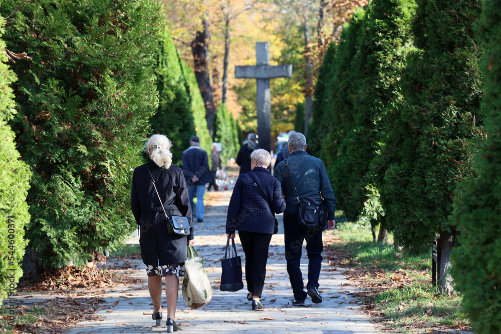 Polski cmentarz w czasie święta zmarłych odwiedzają starsi ludzie. - obrazy, fototapety, plakaty 