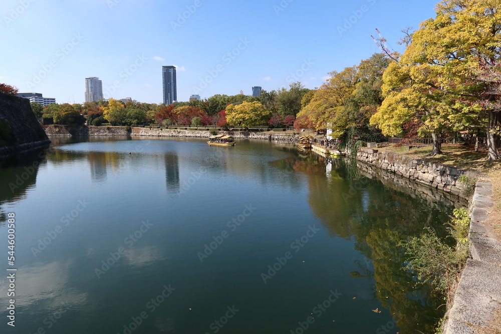 Obraz premium A Japanese castle : the moat and stone wall of Osaka-jyo Castle and an excursion boat in Osaka City 日本のお城：大阪市の大阪城の堀と石垣と観光ボート