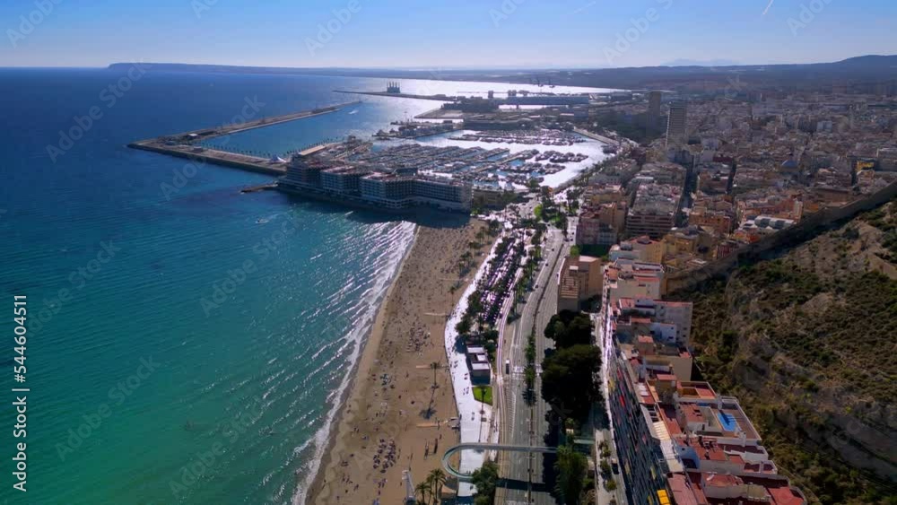 Aerial drone shot of playa del postiguet in Alicante Spain with the marina and small sailing ships in the background. Aerial drone shot of playa del postiguet in Alicante Spain with the marina and small sailing ships in the background.