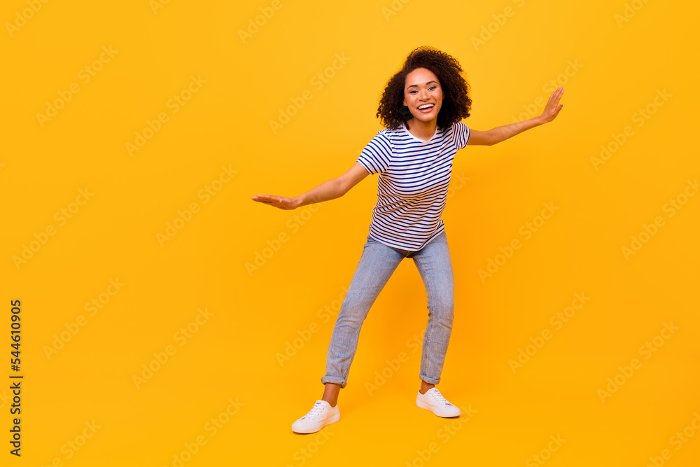 Full body photo of charming cheerful girl hands make moves dancing isolated on yellow color background Full body photo of charming cheerful girl hands make moves dancing isolated on yellow color background
