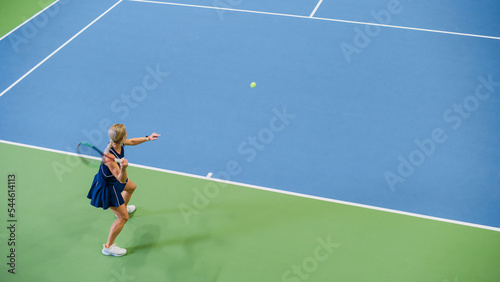 Female Tennis Player Servers by Hitting Ball with a Racquet During Championship Match. Professional Woman Athlete Strikes Successfully. World Sports Tournament. High Angle Wide Shot.
