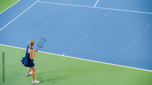 Female Tennis Player Just Served by Hitting Ball with a Racquet During Championship Match. Professional Woman Athlete Successfully Strikes. World Sports Tournament. High Angle Shot. © Gorodenkoff