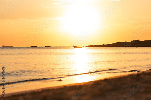 Fototapeta Naklejka Na Ścianę i Meble -  Orange sunset sky and sun over the sea. Water surface and outlines on the horizon.