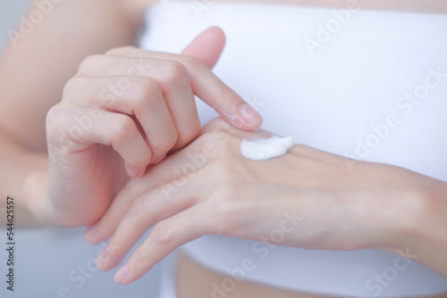 hands skin protection. closeup asia woman applying protective cream on hand.