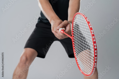 Badminton player wearing sportswear standing holding a racket. © Naypong Studio