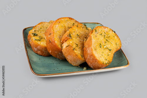 Appetizing garlic bread on a plate on a light gray background