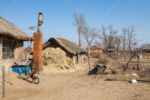 HUNCHUN, JILIN PROVINCE, CHINA: old small farming house with mud walls and thatch roof, called Hanok in Korean, Yanbian Korean Autonomous Prefecture, home to an important community of Korean origins photo