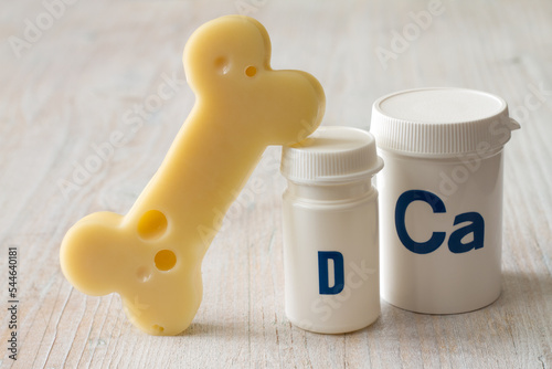 Bone shaped cheese and dietary supplements with calcium and vitamin D, strong and healthy bones concept
