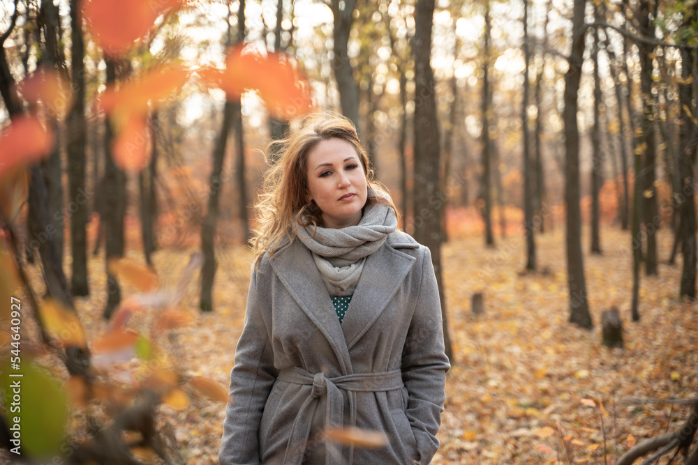 girl in a coat in the autumn forest. redhead woman walking in the park. Close portrait of beautiful woman. basket with leaves girl in a coat in the autumn forest. redhead woman walking in the park. Close portrait of beautiful woman. basket with leaves