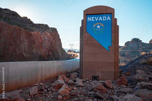 Hoover Dam, USA, September 16,2022.Battle Born Nevada Text With Logo On Brown Signboard By Bridge At Hoover Dam Against Clear Sky