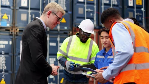 Container import export and logistic concept. Foreman and engineer holding using clipboard and wears PPE to checking inventory or job details with cargo container background.