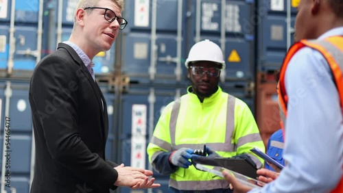 Container import export and logistic concept. Foreman and Maintenance engineer working for inspection the equipment at container yard with cargo container background.