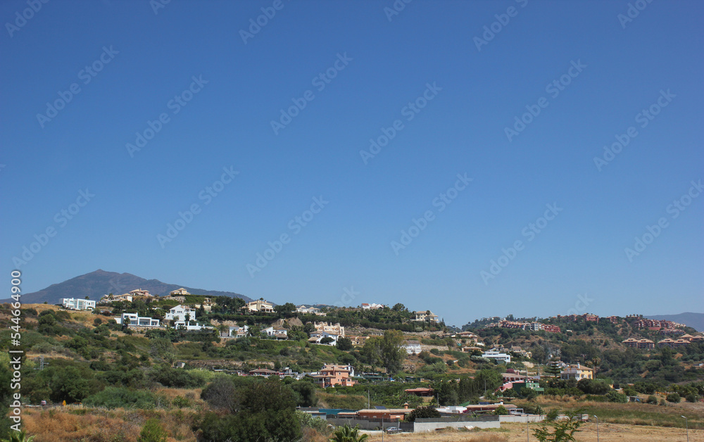 PANORAMIC VIEWS OF SUMMER HOUSE IN THE MOUNTAINS WITH CLEAR BLUE SKY